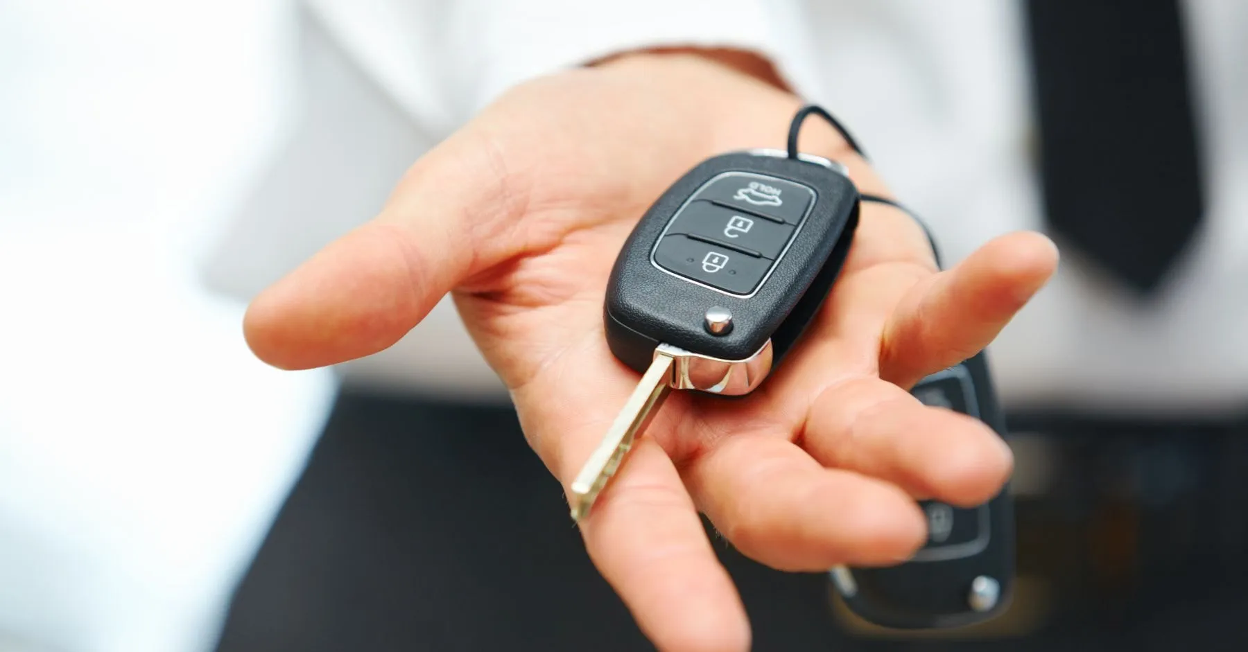 Ein Fahrzeughalter, der einen Autoschlüsel in der Hand hält.